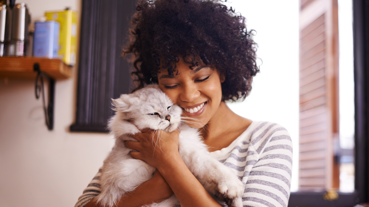 Woman cuddles a grey cat at Elysian Academy